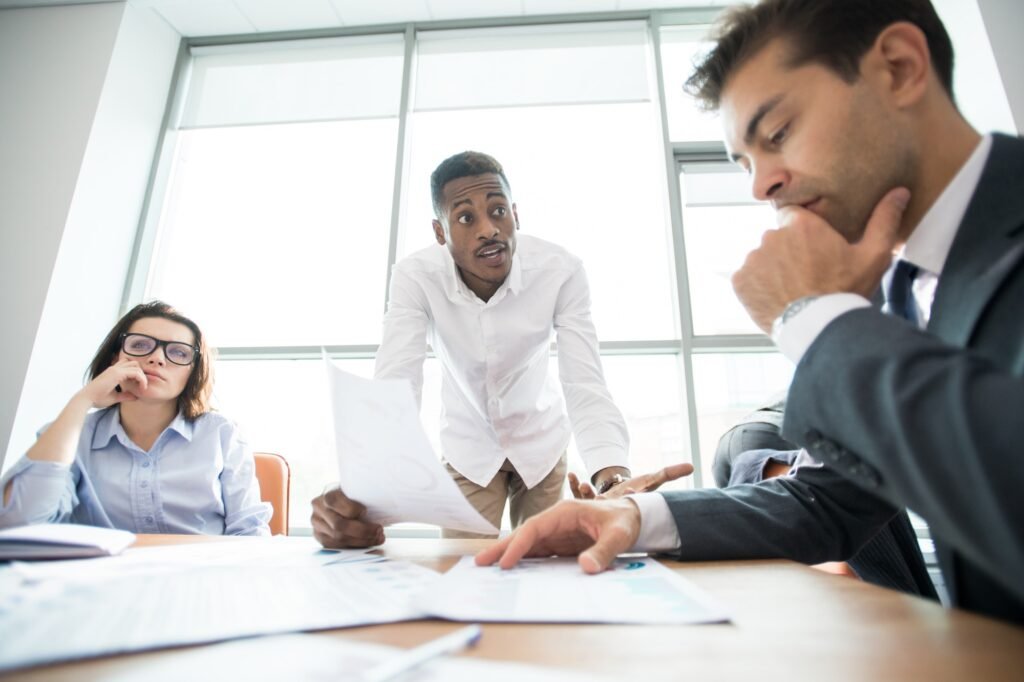 African manager asking staff about mistake at meeting