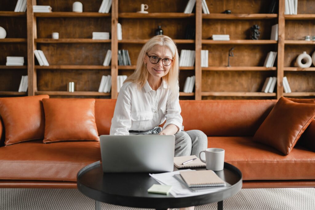 Businesswoman CEO freelancer teacher working on laptop in home office watching webinars, e-learning